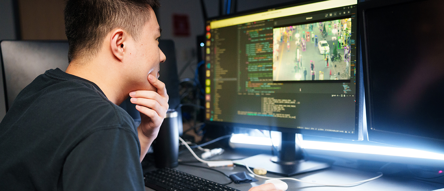 A young man looking at a computer screen