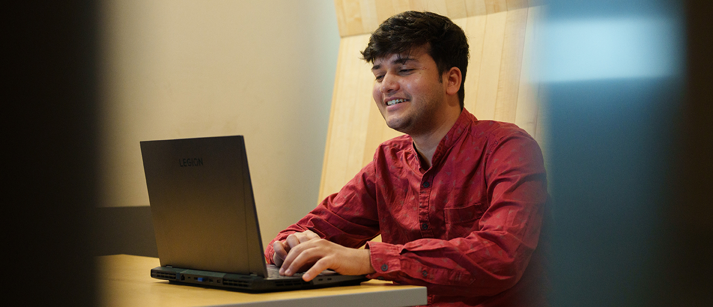 A young man working at a laptop