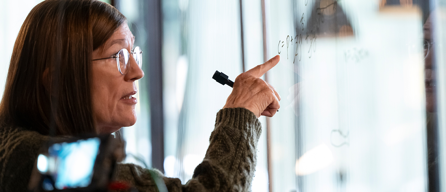 A woman writing on a white board