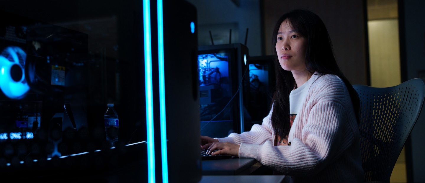 A woman in a dark computer lab