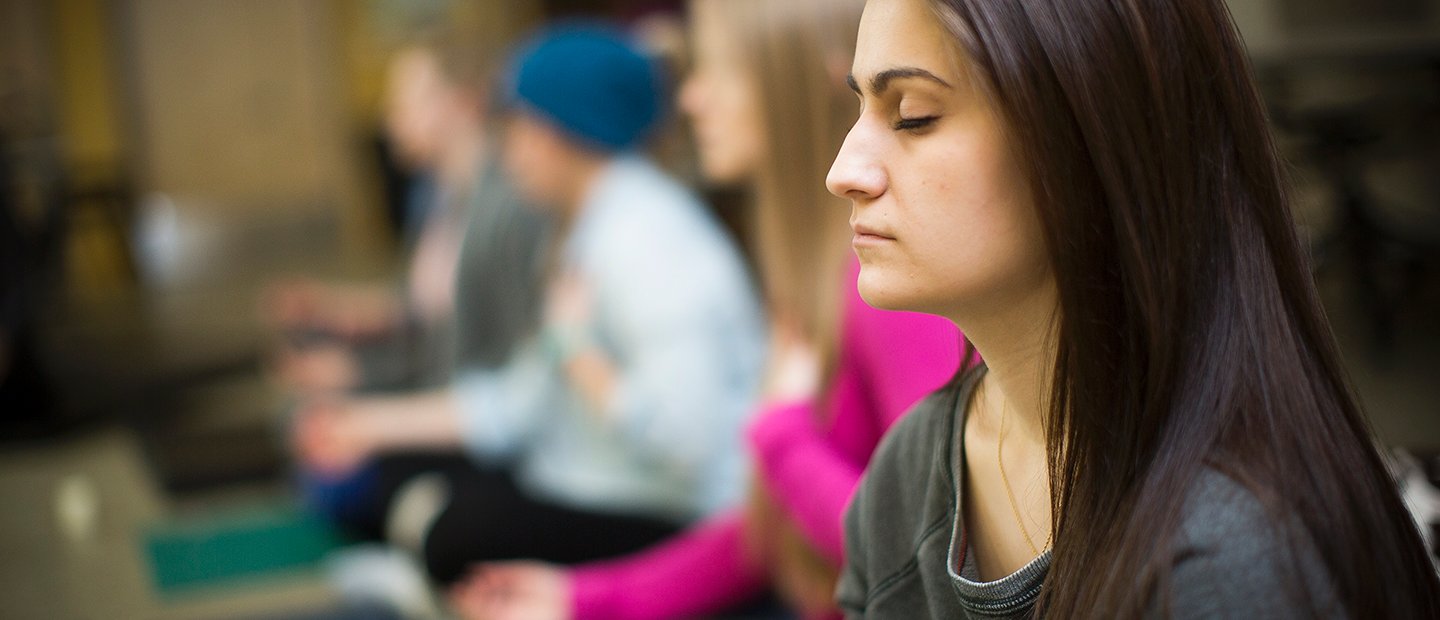Woman with her eyes closed, meditating in a class.