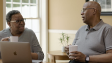 An older couple seated at a laptop together
