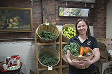 image of Jennifer Lucarelli holding a basket of fruits and vegetables in a market