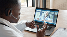 Healthcare worker conducting telehealth appointment on a laptop