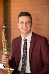 A photo of Ben MacDonald holding a musical instrument