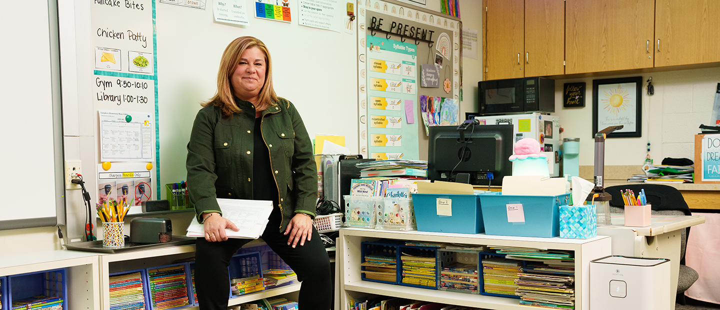 A teacher seated at the front of a classroom
