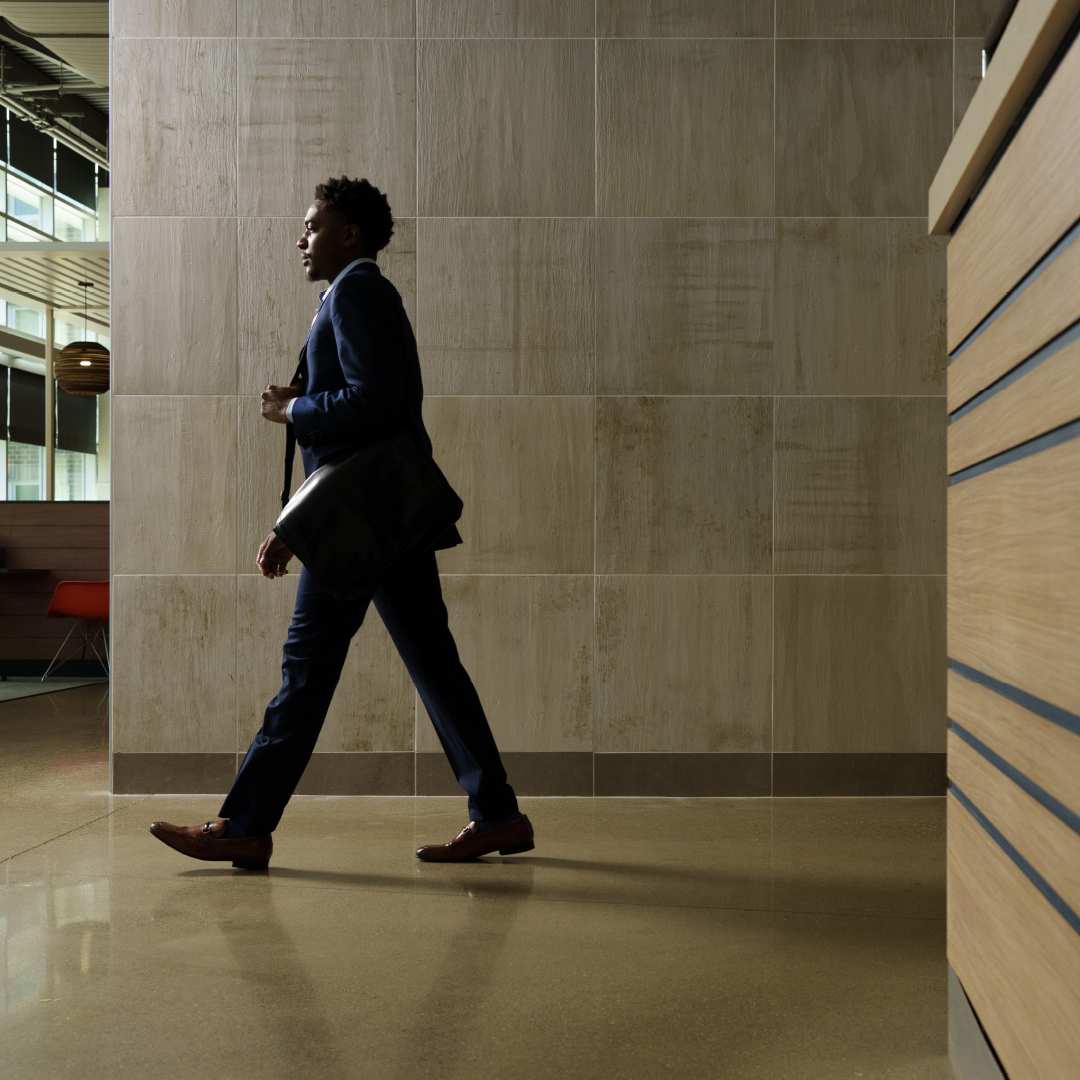 A man in a business suit walking down a hallway