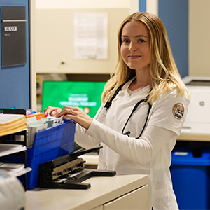 BSN student, Bridgette, at the desk of a doctor's office.